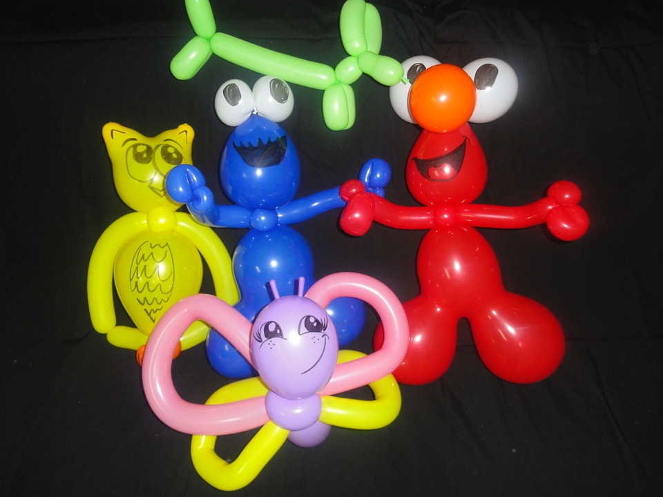balloon twisting of an owl, butterfly, and Sesame Street characters