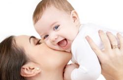 woman kissing baby cheek