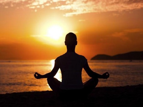 Male meditating near ocean