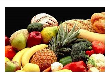 fruits and vegetables with bread in the background