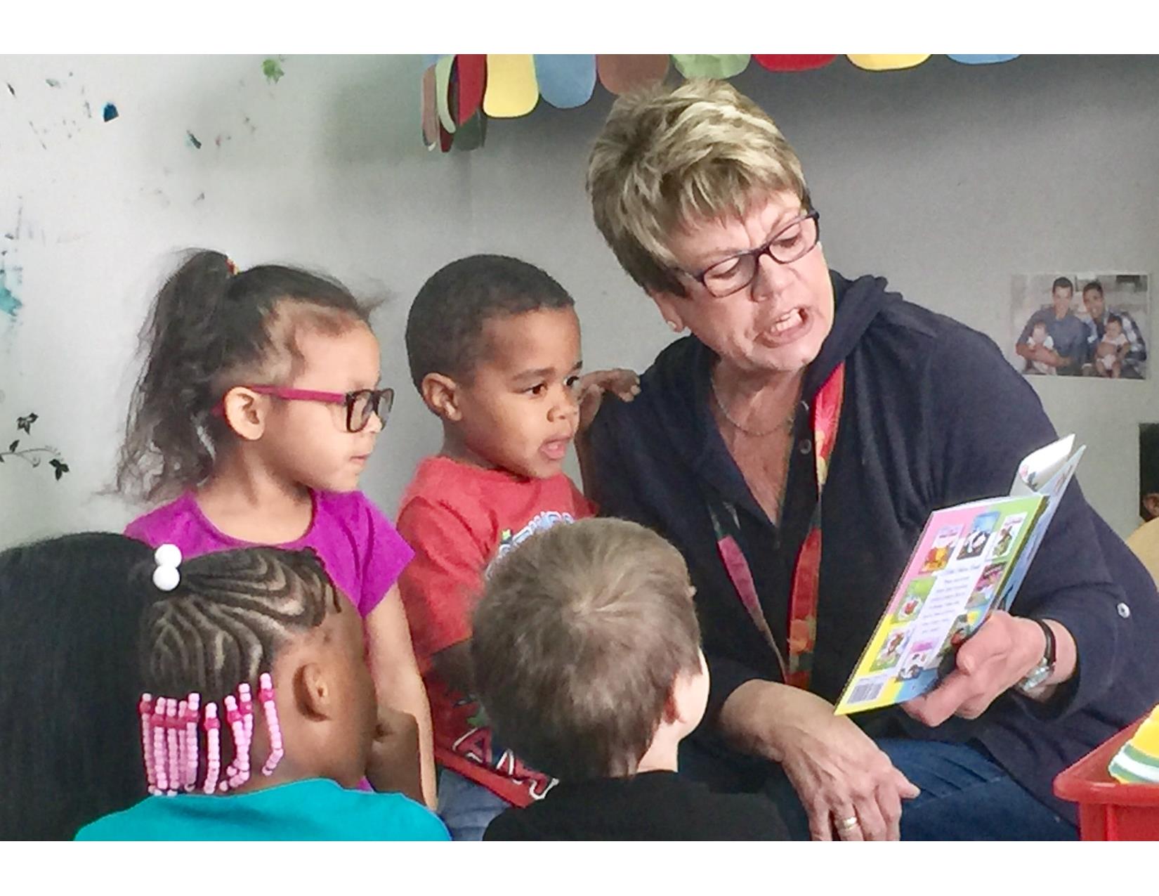 Adult reading to three children