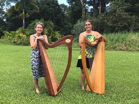 Two harpists on grass lawn