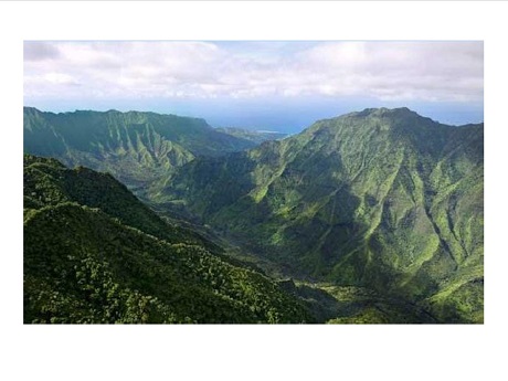 View of the Wainiha Valley with green mountains and clouds against blue sky