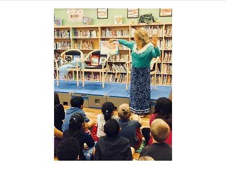 woman reading book to children