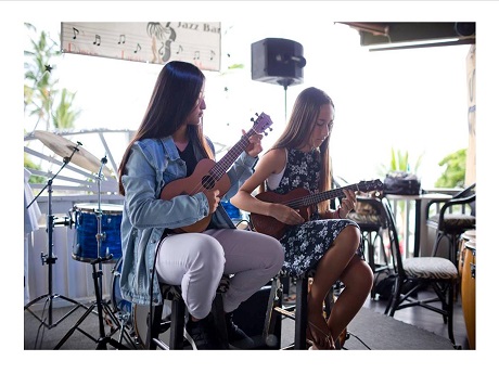 Teens playing ukelele on stage