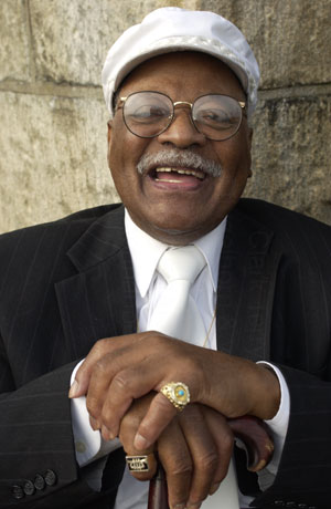 Older man in a suit smiling