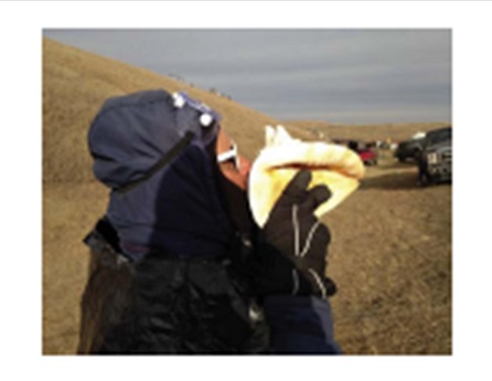 Man blowing conch shell