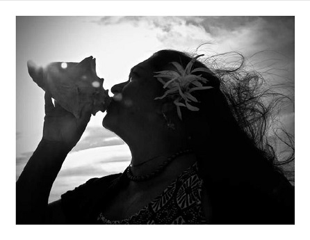 woman blowing conch shell