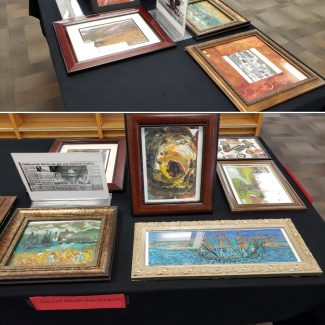 seven oil on canvas paintings in frames on a black tablecloth