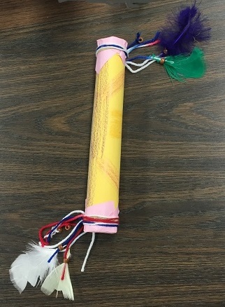 yellow rainstick with feathers at the end