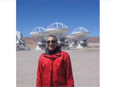 Dr. Jonathan Williams standing in front of satellite dishes