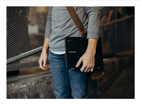 Teen boy carrying Chromebook