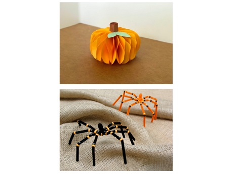 a paper pumpkin and two pipecleaner spiders