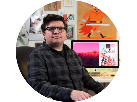 man in plaid shirt sitting and looking at camera with art behind him