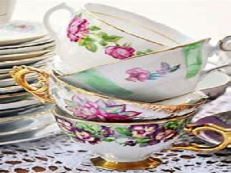 four teacups piled on top of each other with saucers stacked in the back