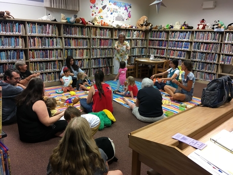 A crowd of parents and children participating in 'Play With Me' at the Kailua-Kona Public Library