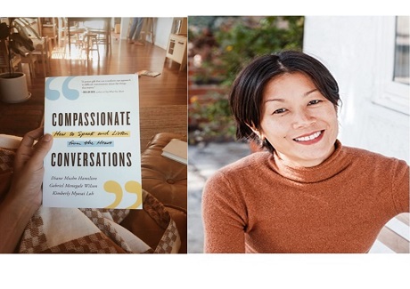 Book held by sitting person in living area with another person in the background