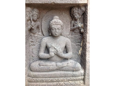 Photo of statue of the Buddha sitting with legs crossed.