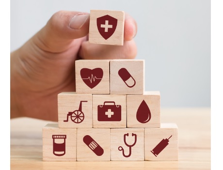 A stack of ten wooden blocks with healthcare related images