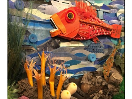 Orange fish in underwater scene made from trash materials