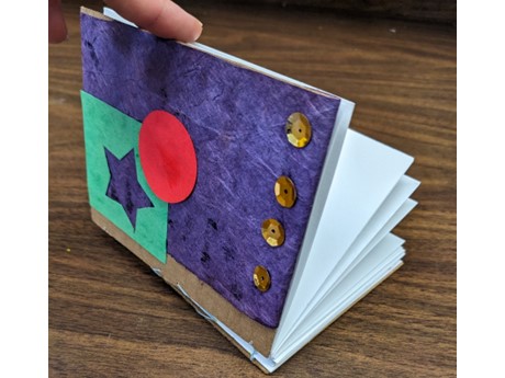 Hand made book being held open.