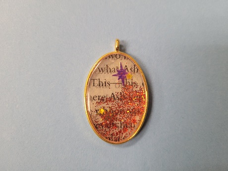 Resin craft pendant using recycled book pages.