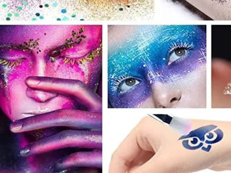 People wearing body art. On the left is a woman with sparkly pink paint and gold glitter. The person on the right has a sparkly paint mask in blue, silver, and purple. The person on the bottom right is painting an owl on their hand.