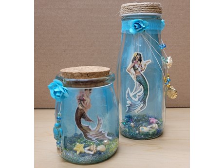 Homemade crafts showing a mermaid scene in two different sized jars